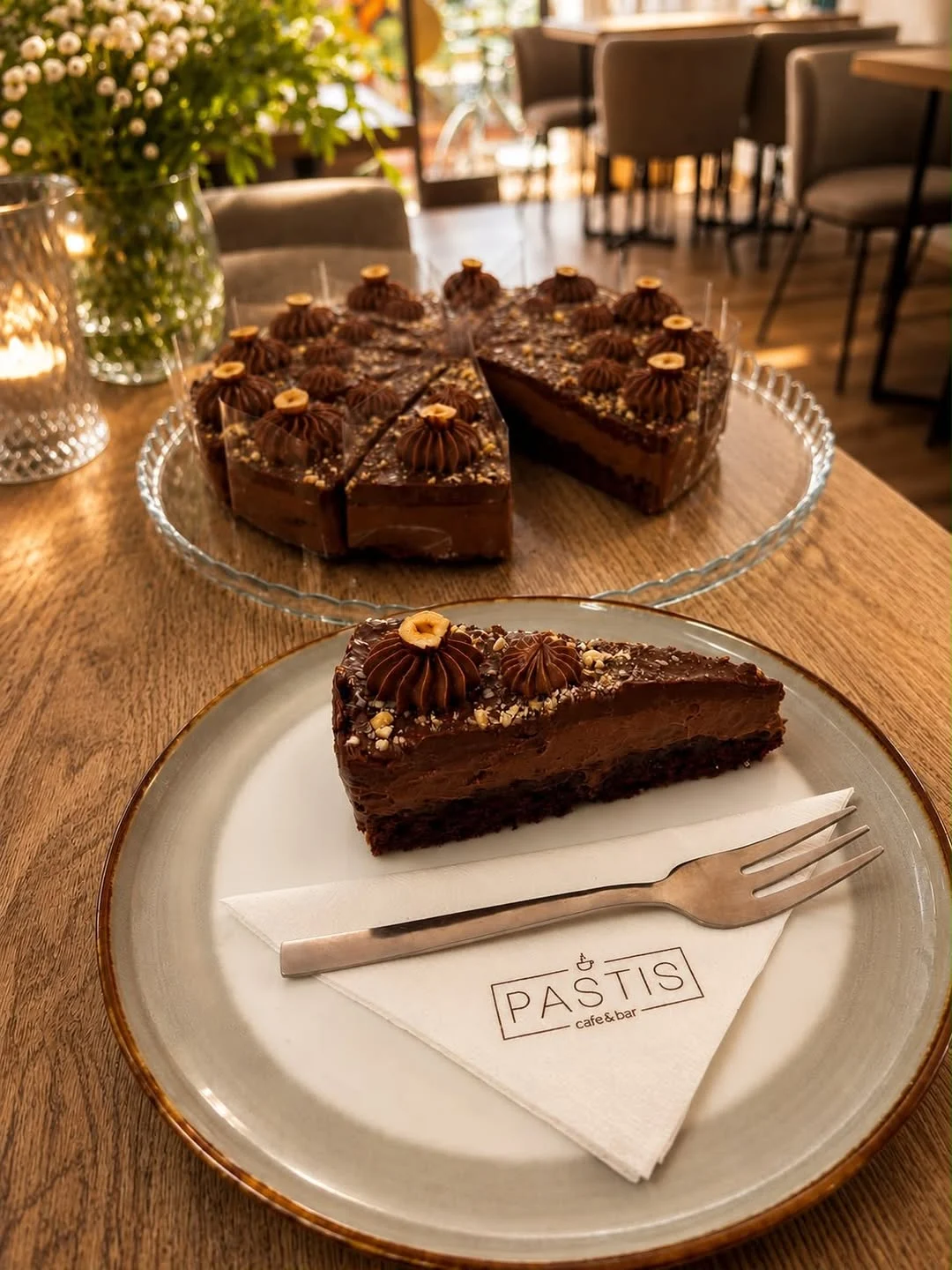 Čokoládová torta s orieškovým krémom na tanieri s obrúskom PASTIS